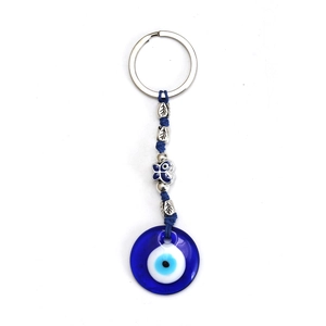 Dettaglio del ciondolo turco Evil Eye in vetro blu con farfalla argentata e foglia