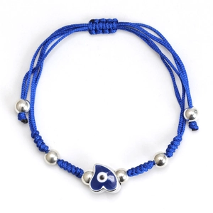 Detail of blue braided rope bracelet with heart evil eye pendant and silver beads