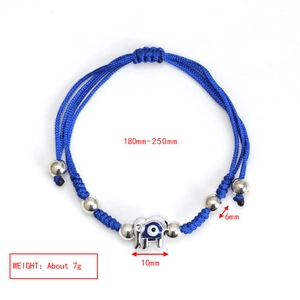 Detailed view of the woven blue rope bracelet with silver elephant and evil eye charm