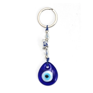 Dettaglio del ciondolo malocchio in vetro blu con corda intrecciata e uccellino in argento