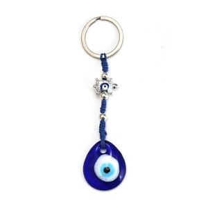 Dettaglio del ciondolo Malocchio in vetro blu con corda intrecciata e tartaruga in metallo