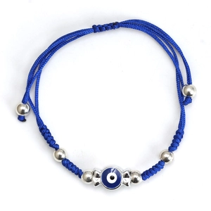 Close-up of blue braided cord bracelet with Nazar evil eye charm and silver metal beads