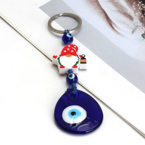 Detail of Christmas gnome keychain featuring blue evil eye charm and braided rope