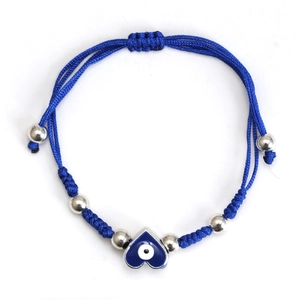 Close-up of blue braided rope bracelet featuring silver beads and a heart evil eye charm