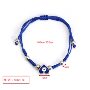 Detail showing blue heart evil eye charm on adjustable woven rope bracelet with silver beads