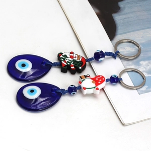 Detail of Christmas evil eye keychains with blue glass charms and Santa figurines