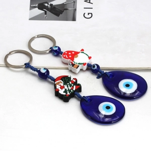 Detailed view of Christmas Evil Eye keychains with Santa Claus and blue glass charms