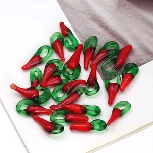 Macro shot of red glass chili pendants with green loops for DIY jewelry making
