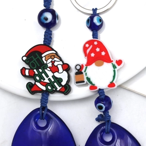 Close-up of Santa and gnome charms with blue Evil Eye beads and teardrop glass pendant