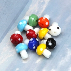 Close-up of colorful mushroom-shaped glass beads with white polka dots for DIY jewelry