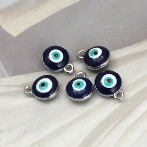 Detail view of five blue evil eye charms with silver frames and glazed finish