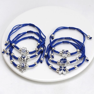Macro shot of blue braided bracelets featuring evil eye charms in silver metal finish
