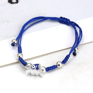 Detailed macro of a blue braided rope bracelet with a heart-shaped evil eye charm and beads