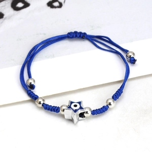 Close-up of blue braided Evil Eye bracelet with silver star pendant and adjustable slider knot