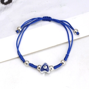 Detail of blue braided evil eye heart charm bracelet with adjustable silver bead cord
