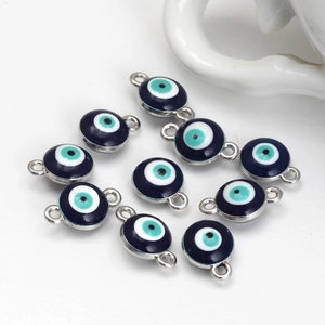 Macro detail of blue evil eye charms with silver metal frames and double loops