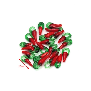 Macro detail of 20mm red glass chili pepper charms with green loop for DIY jewelry