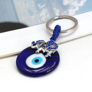 Detail of blue evil eye bead and silver elephant charm with rhinestones on keychain