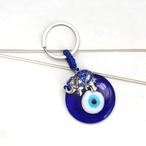 Elephant evil eye keychain with blue glass nazar charm and rhinestones on white background