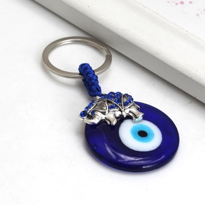Close-up of Turkish evil eye charm with silver elephant and blue rhinestones detail