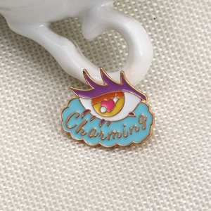 Detailed macro view of the enamel evil eye brooch featuring heart pupil and Charming text