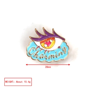 Detail showing cartoon enamel eye brooch with Charming text and colorful cloud design