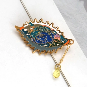 Artistic enamel eye brooch detail featuring a sleeping cat on moon with crystal drop