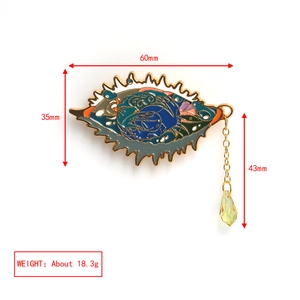 Detailed view of evil eye brooch with colorful enamel work and gold chain teardrop