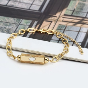 Detail view of gold hexagonal column evil eye bracelet with sunburst texture and adjustable link chain