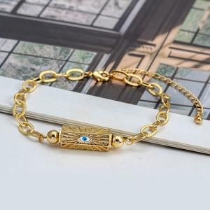 Detail of gold evil eye bracelet featuring textured chain links and blue enamel inlay