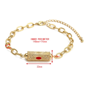 Detail of gold evil eye charm bracelet featuring sunburst pattern and red enamel inlay