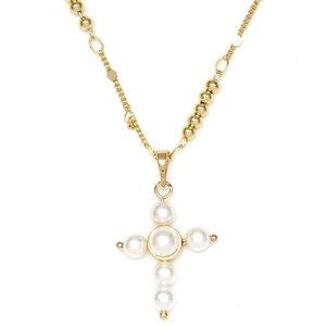 Détail d'un collier chaîne dorée à perles avec un pendentif en croix de perles blanches
