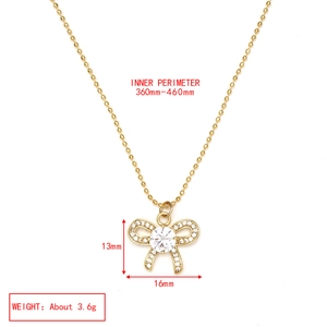 Détail d'un collier chaîne à billes dorées avec pendentif nœud en cristal et micro-zircons