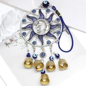 Detail of sun and moon evil eye ornament with five gold bells and blue enamel inlay