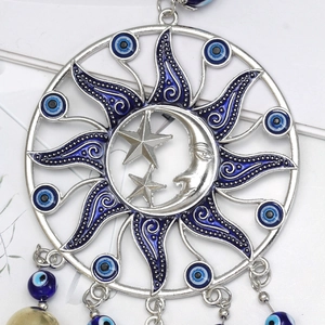 Detailed macro view of the silver sun moon pendant with blue evil eye beads and charms