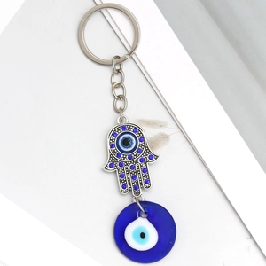 Detail of Hamsa Hand keychain with blue crystal pavé and Turkish Evil Eye glass charm