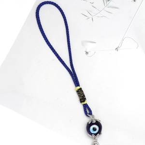 Detail of blue glass evil eye pendant with braided nylon cord and silver alloy floral caps