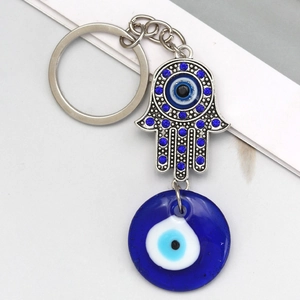 Detailed view of silver Hamsa Hand keychain with blue rhinestones and Nazar evil eye glass