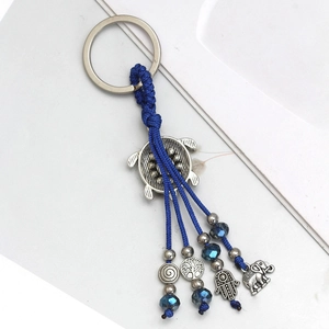 Detail of evil eye keychain with turtle, hamsa, tree of life, and elephant charms