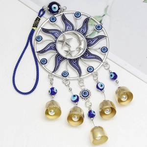 Detail of silver Evil Eye pendant with sun and moon frame, blue beads and brass bells