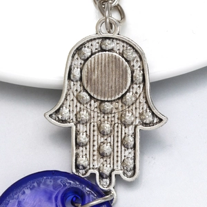 Detail view of Hamsa Hand keychain with vintage silver alloy finish and dark blue bead
