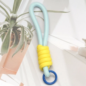 Detailed view of handmade woven key chain in light blue and yellow with circular hook