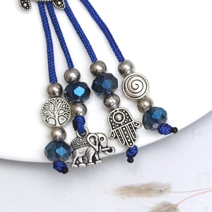 Detail of blue Hamsa Hand and Elephant pendants on a bohemian evil eye keychain decor