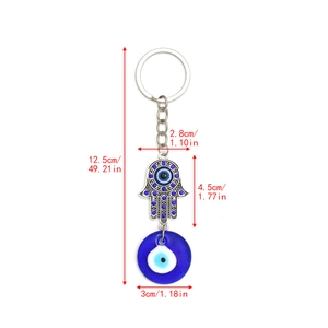 Detailed view of silver Hamsa Hand keychain with blue crystal and Evil Eye glass charm