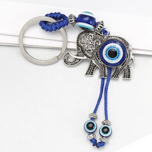 Macro detail of elephant evil eye keychain with blue braided rope and silver alloy plating