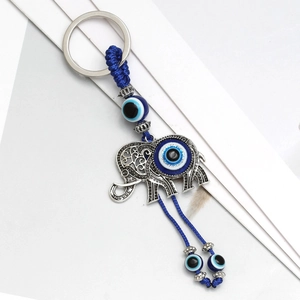 Detail of Turkish evil eye elephant keychain with vintage silver finish and blue woven rope