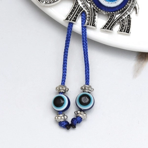Detailed view of evil eye beads on braided cords attached to elephant keychain