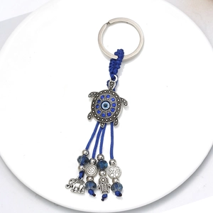 Detailed view of turtle evil eye keychain with elephant, tree of life, and hamsa hand charms
