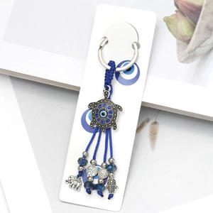 Blue evil eye turtle keychain with hamsa hand, elephant charms and woven tassels