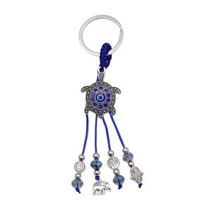 Silver turtle evil eye keychain with blue tassels, hamsa hand, and elephant charms